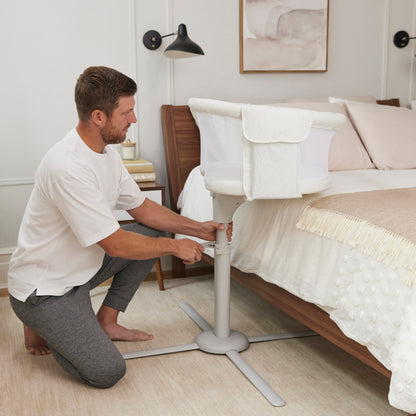 Tėtis reguliuoja HALO BassiNest Swivel Sleeper lovytę, kad mažylis būtų arti ir saugus per naktį. Idealus pasirinkimas artimam ryšiui su kūdikiu!